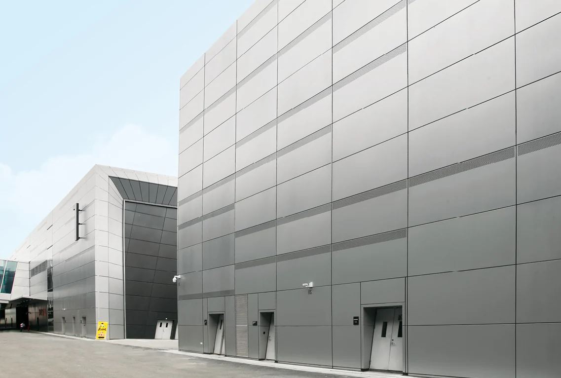 Aluminum facade with horizontal and vertical panel joints around doors and wall openings