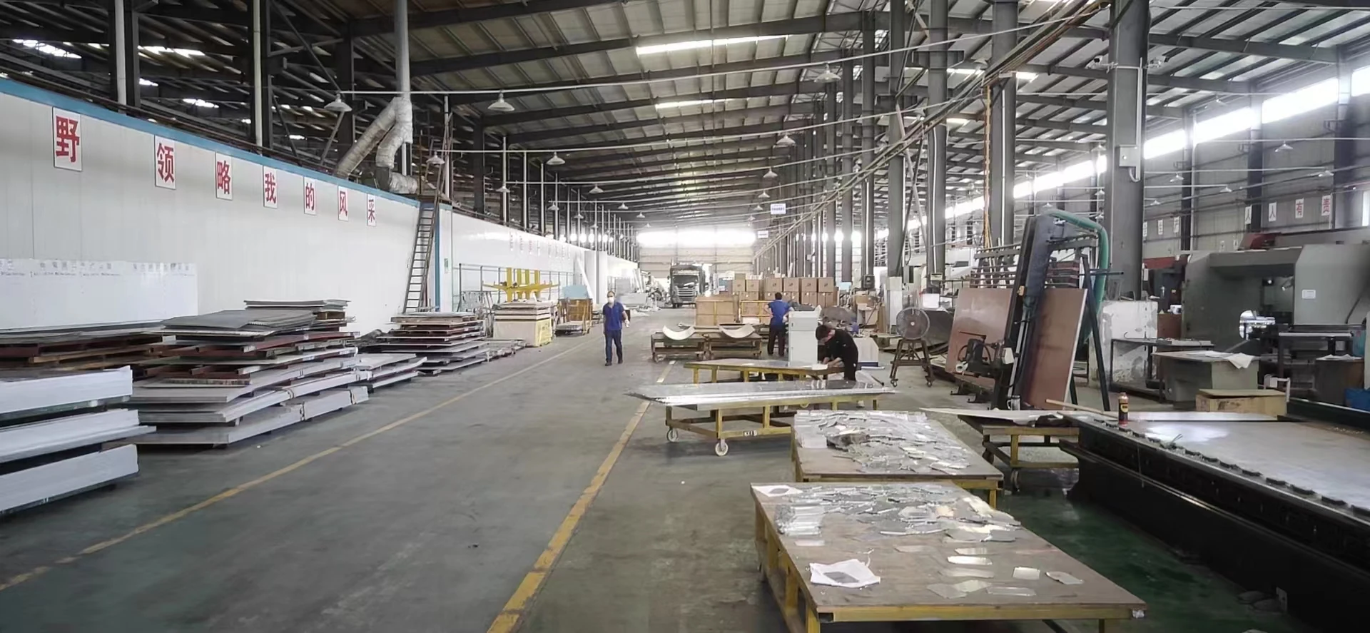 Lianhui sheet-metal fabrication workshop in Foshan with folded aluminum panels, curved sections and assembly workstations