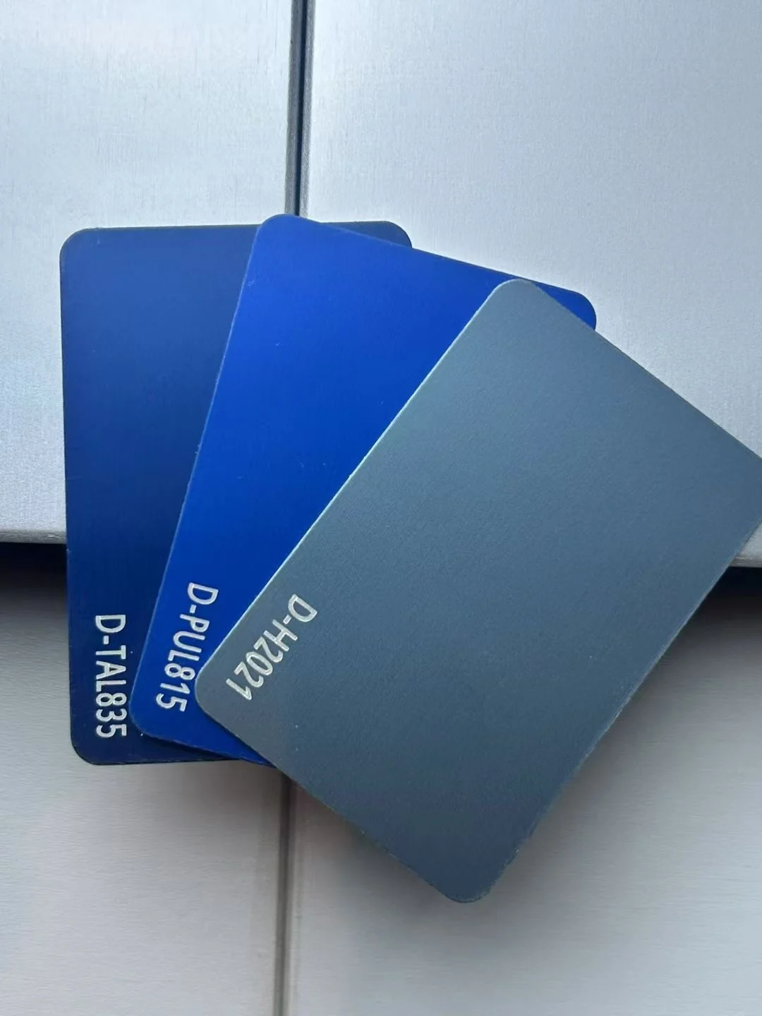Blue and grey aluminum finish samples showing color and surface texture