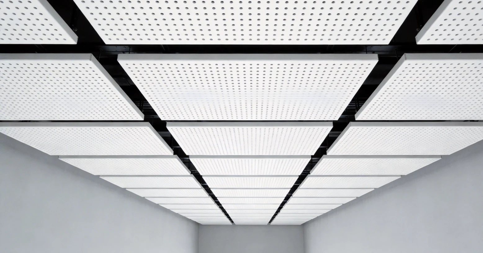 Perforated aluminum ceiling panels with round holes and solid borders arranged in an interior grid
