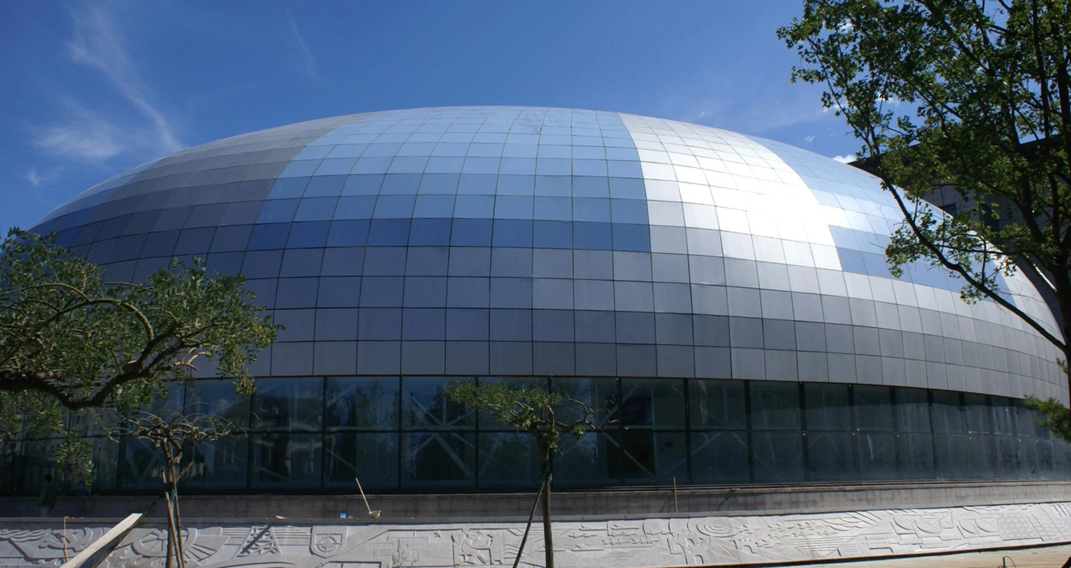 Faceted metal panels following a domed public-building exterior in Beijing
