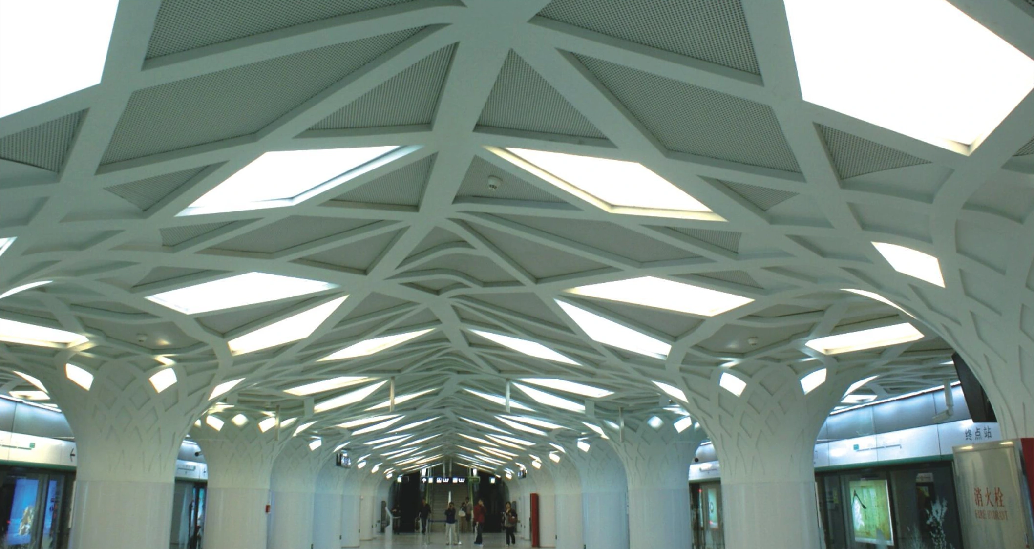 Branching ceiling forms surrounding triangular skylights in a Beijing metro station