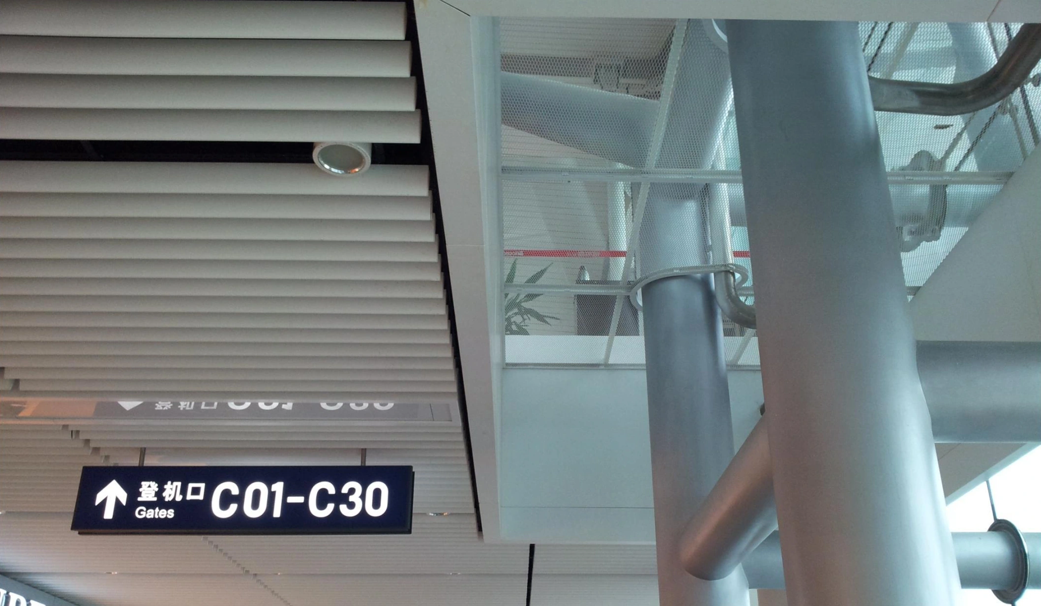 Linear aluminum ceiling louvers above boarding-gate signage at a Chengdu airport terminal