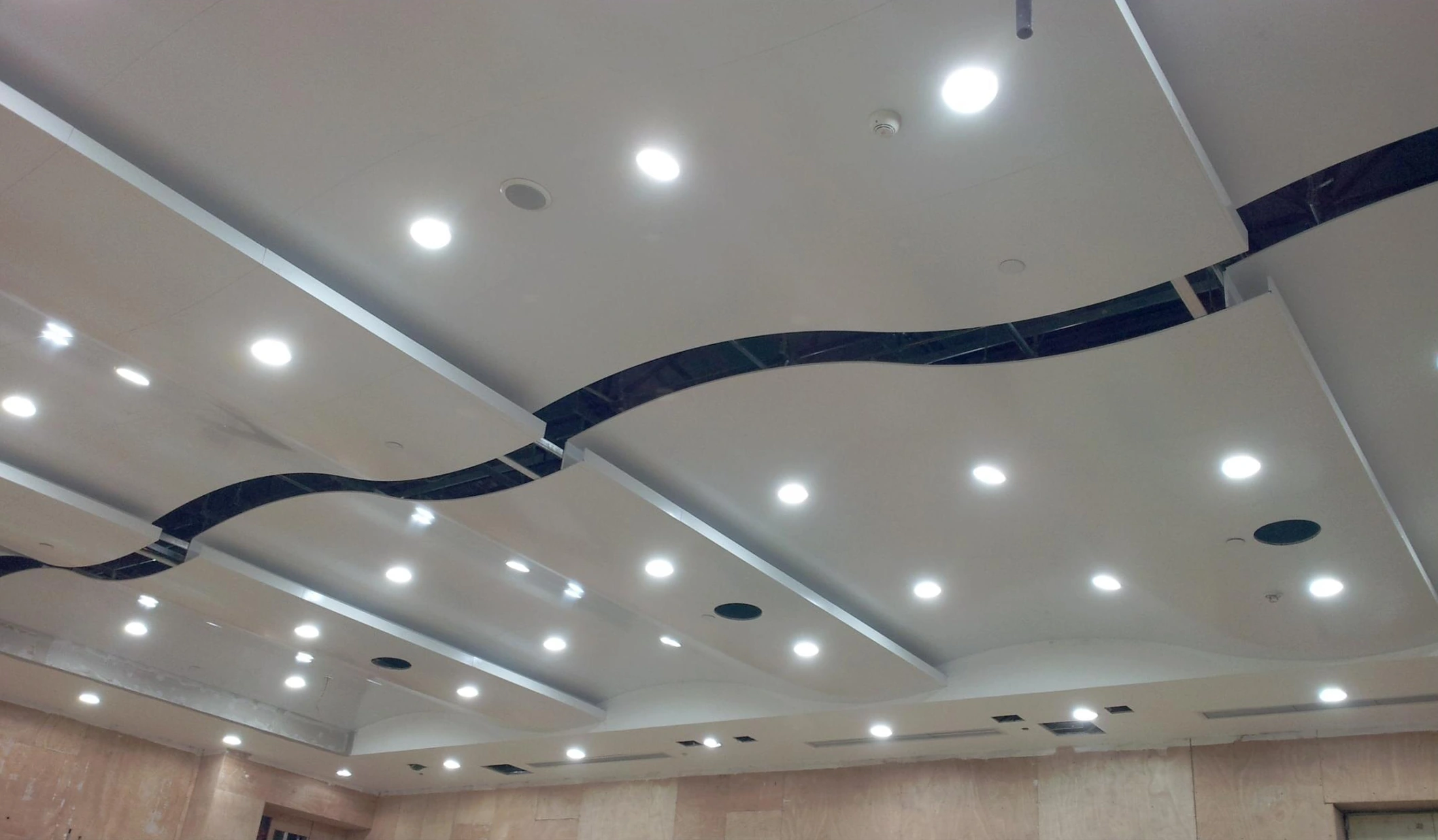 Aluminum ceiling panels with curved dark gaps and recessed downlights in Chongqing