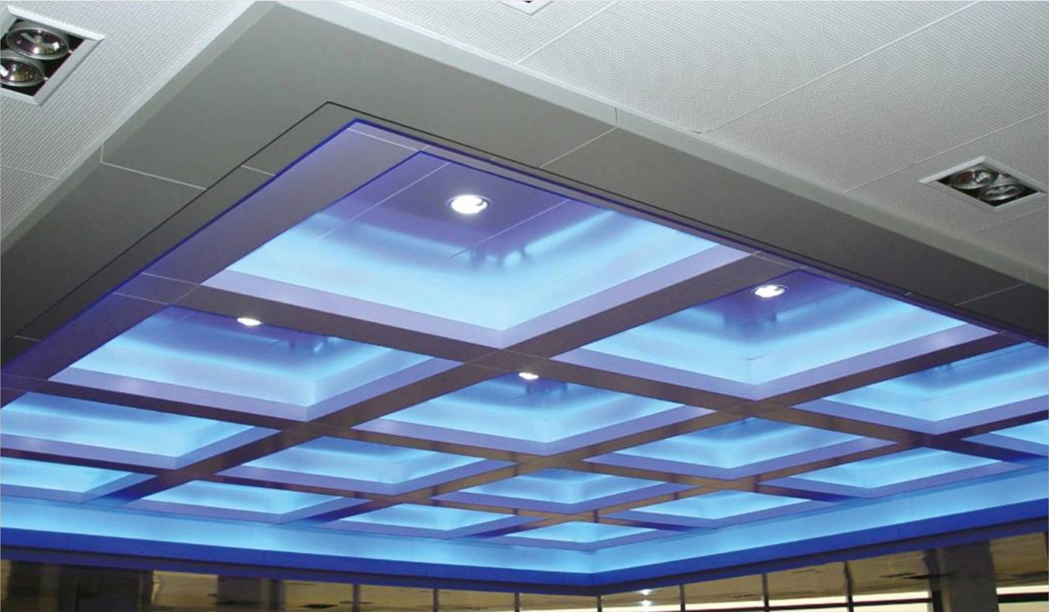 Blue backlit aluminum ceiling grid with recessed lights at a Guangzhou airport terminal