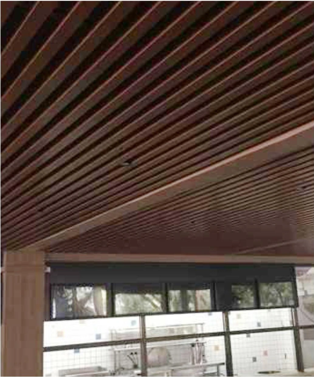 Wood-look linear aluminum ceiling strips above windows in a Guangzhou resort pavilion