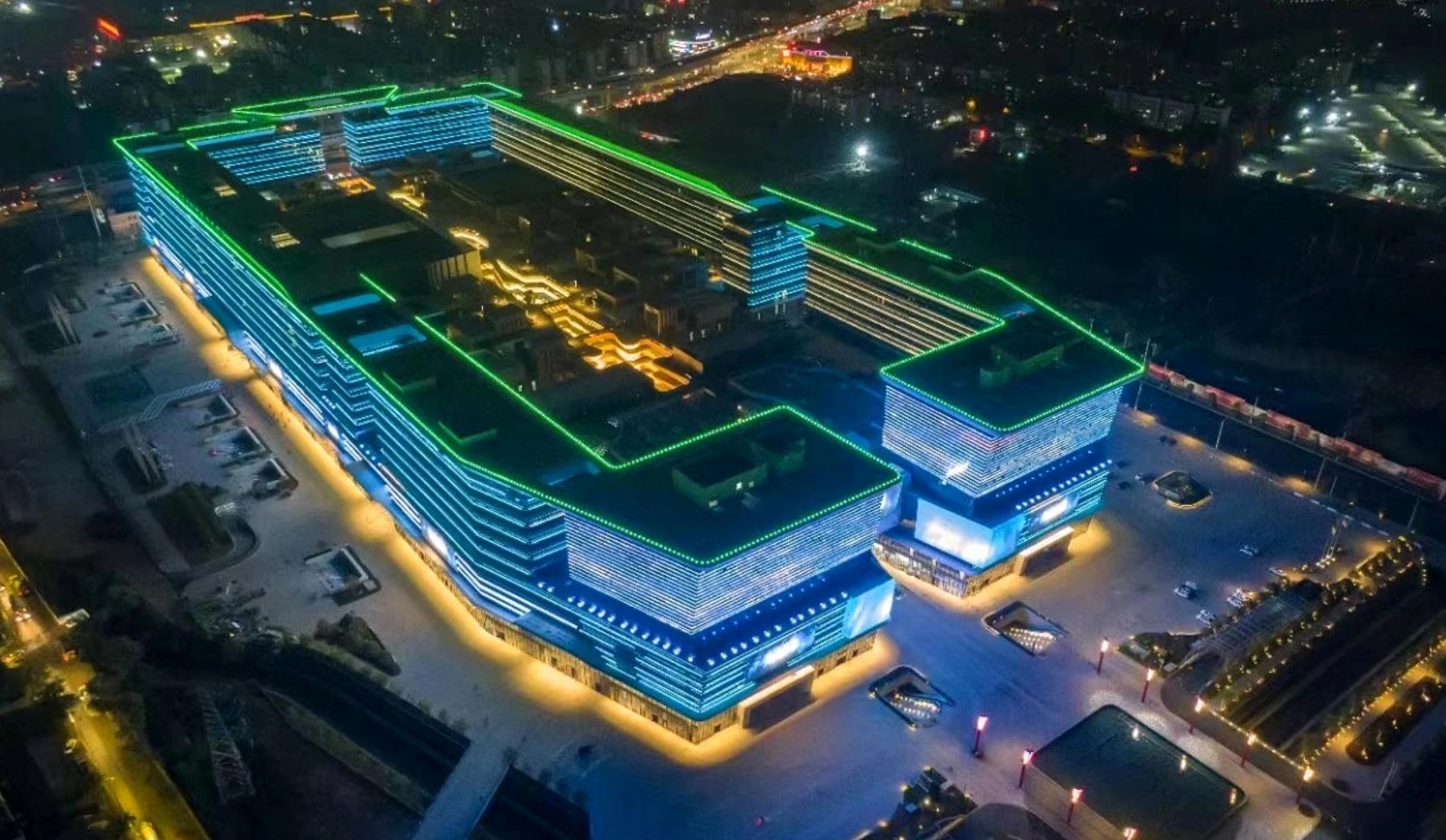 Night aerial view of a Guangzhou exhibition complex with illuminated horizontal facade bands