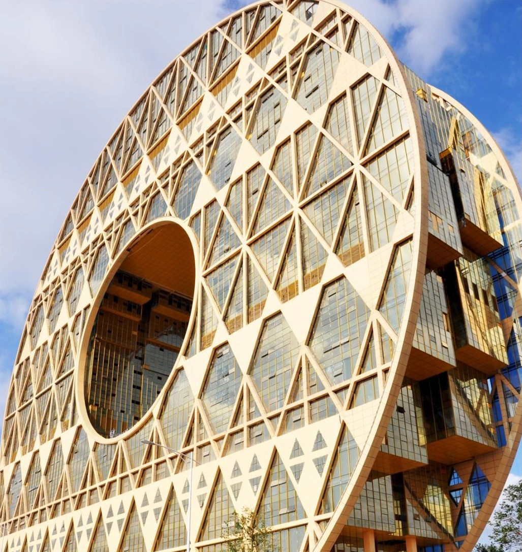 Geometric perforated facade screens around a circular opening on a Guangzhou commercial tower