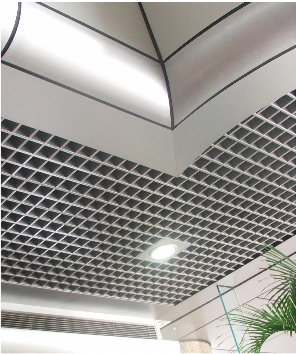 Open-cell aluminum ceiling grid beneath a recessed corner skylight in Guangzhou