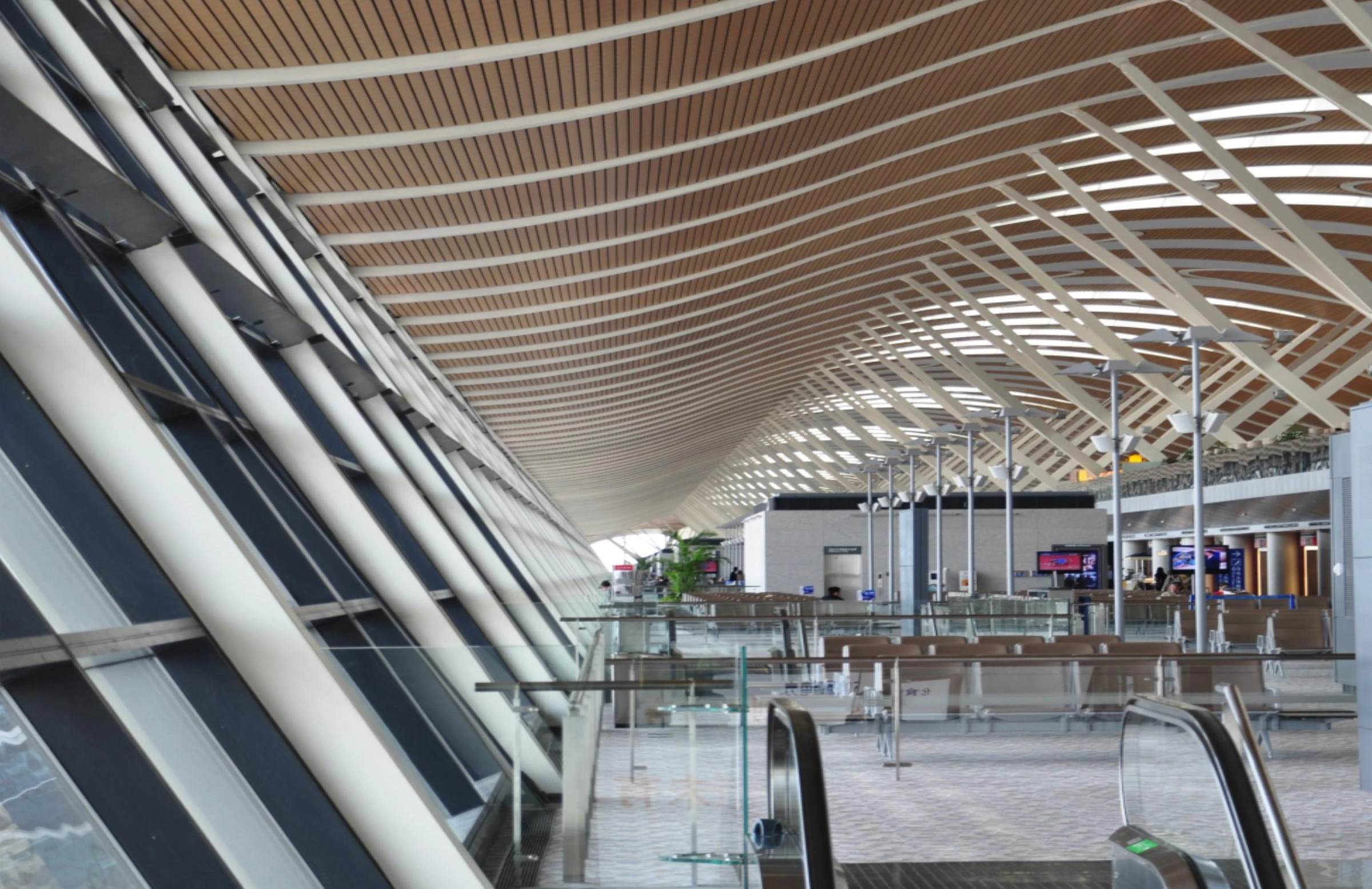 Wood-look ceiling strips following the curved roof of a Hangzhou airport departure hall