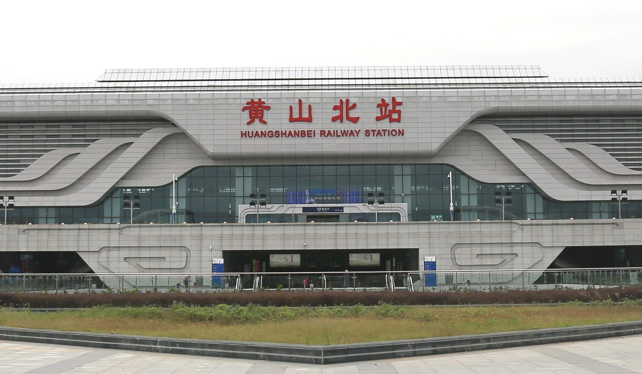 Ribbon-like metal facade bands above the glazed entrance to Huangshan railway station