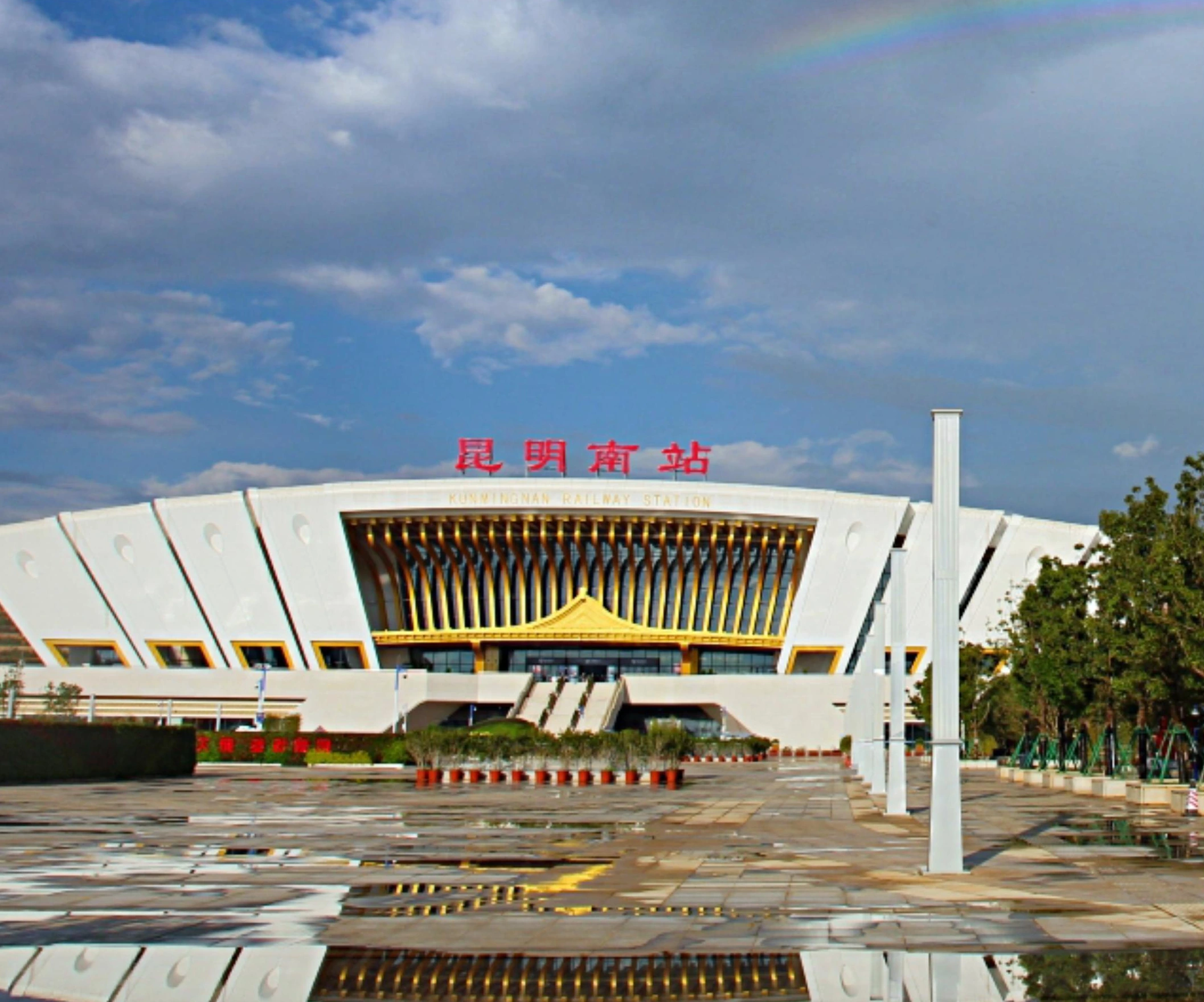 Gold-toned vertical facade fins beneath the curved roof of Kunming railway station