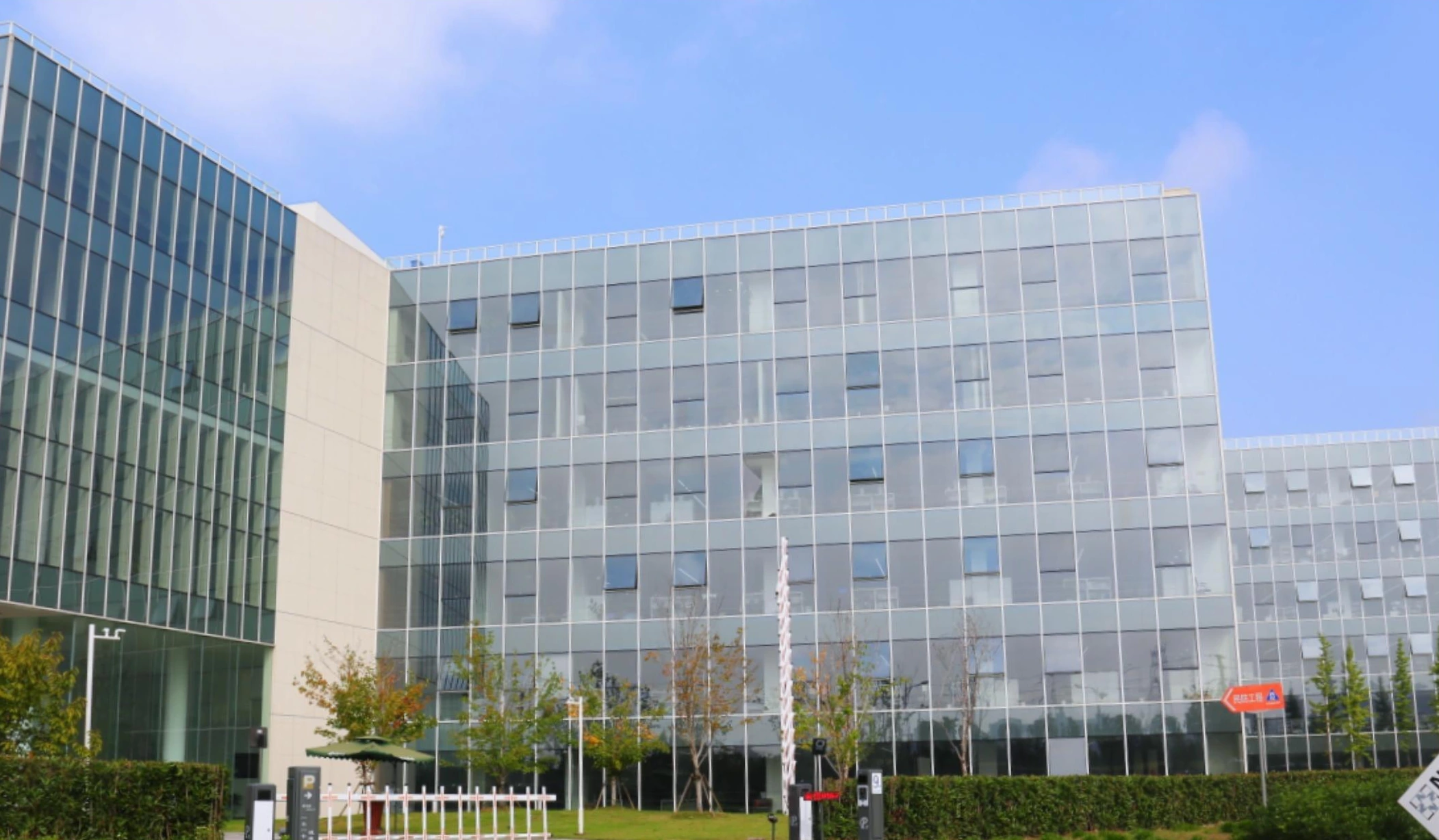 Office building facade with a regular grid of pale panels and glazing in Nanjing