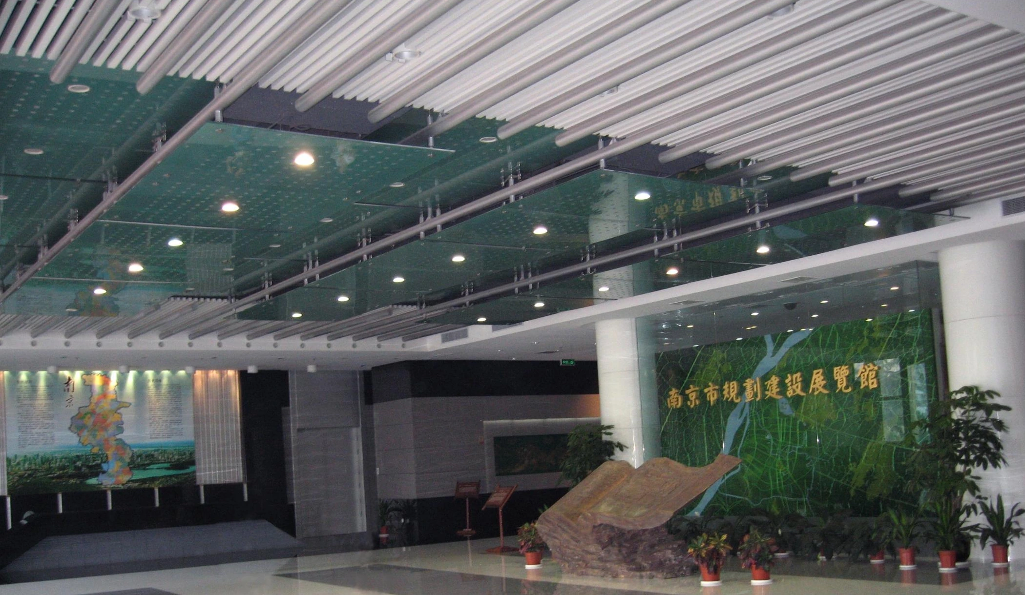 Linear ceiling elements and spotlights above an exhibition display in Nanjing