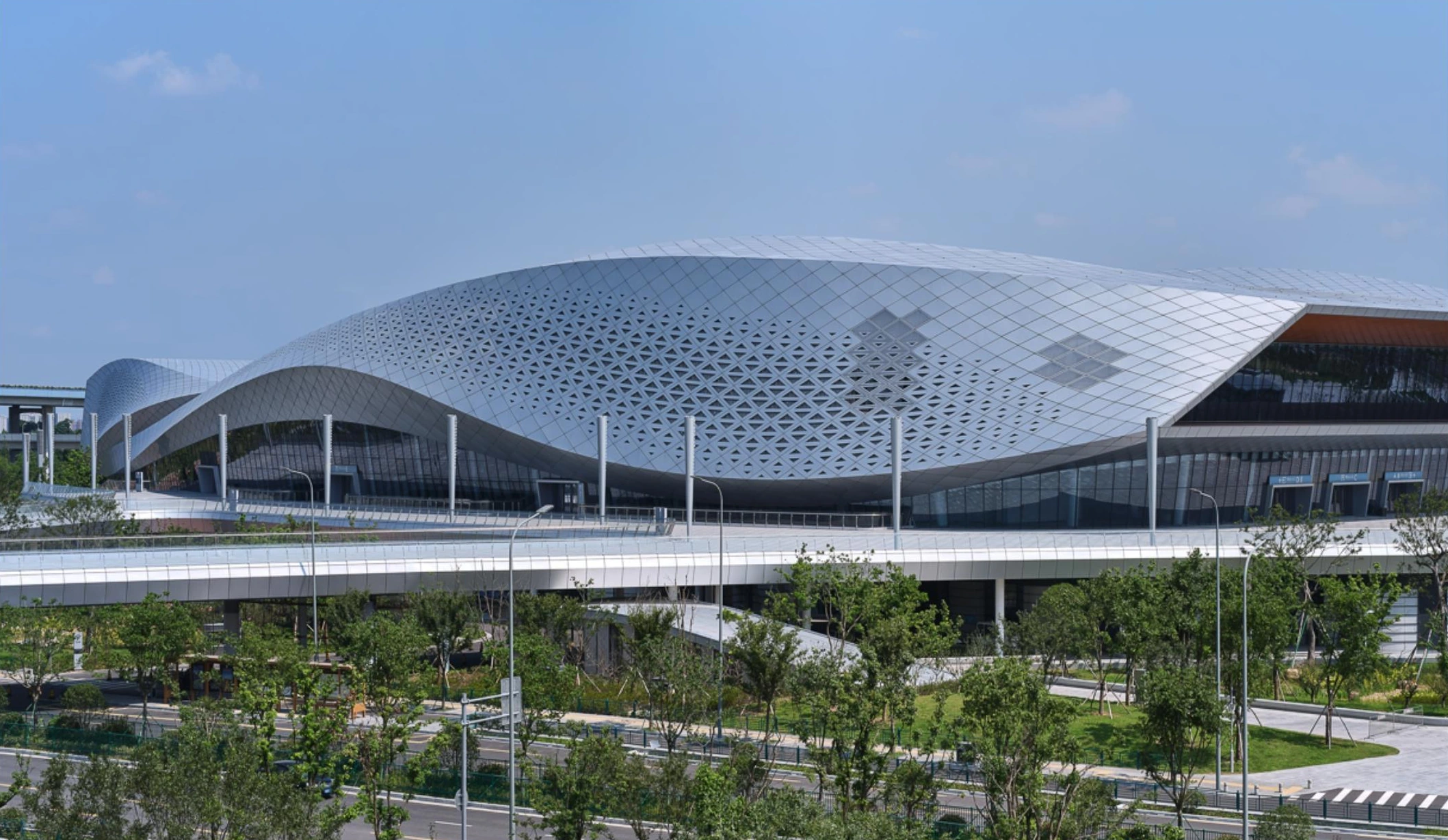Undulating perforated metal roof shell above a sports venue in Ningbo