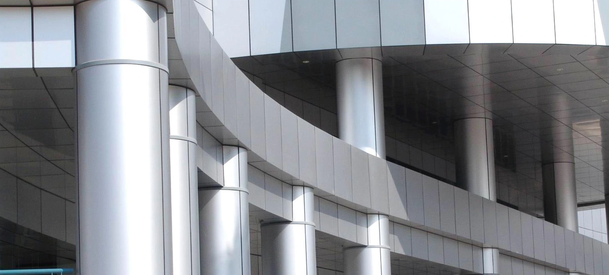 Curved facade fascia, cylindrical columns and metal soffit panels at a Beijing hospital