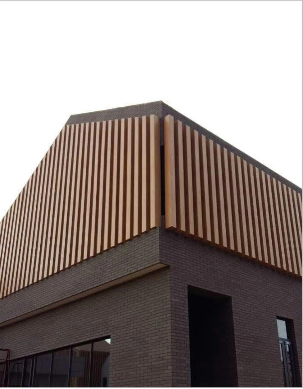 Vertical wood-look aluminum roofline cladding above a villa facade in Shaanxi