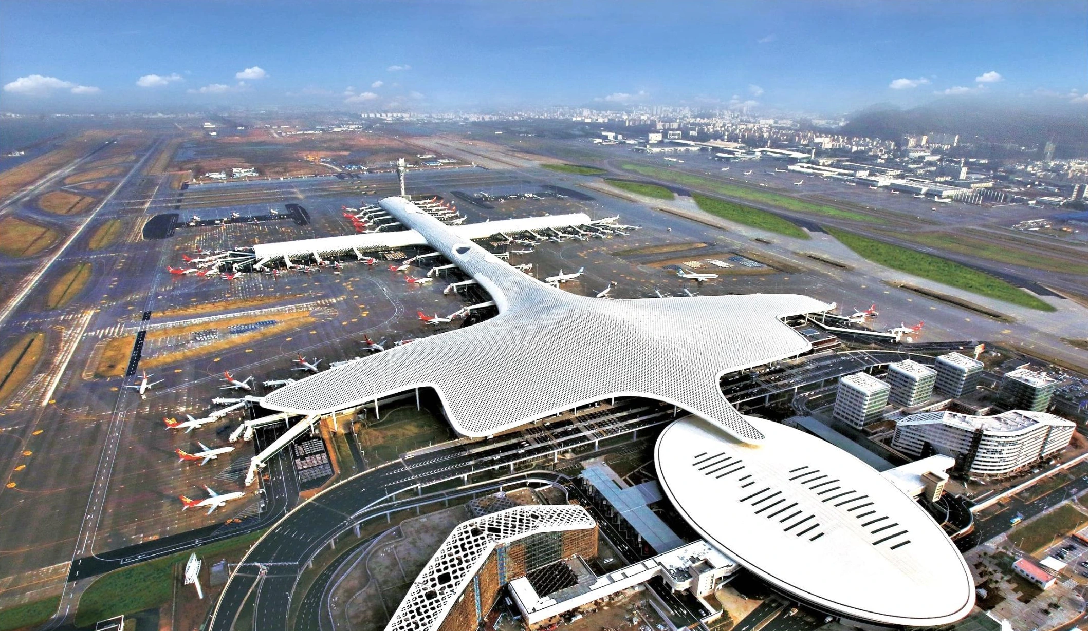 Aerial view of Shenzhen airport terminal showing the branching roof form and patterned exterior