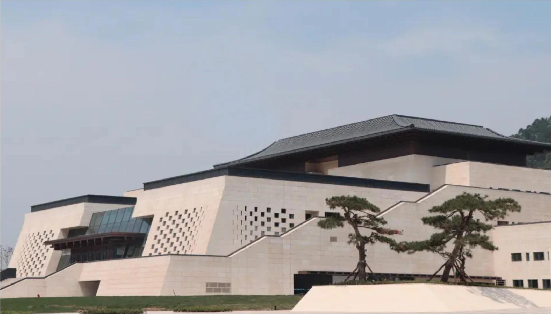 Stone-look facade panels and sloping roof forms on a regional museum in Yibin