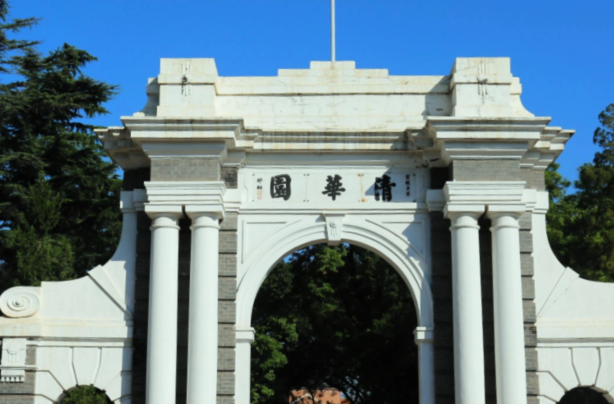 Stone gateway with an arched central opening at a university campus in Beijing