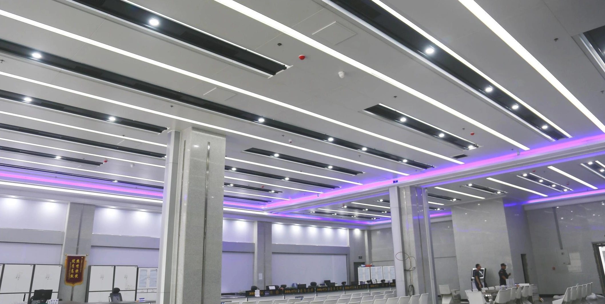 Linear ceiling panels, recessed lighting and ventilation above a Xi'an showroom hall