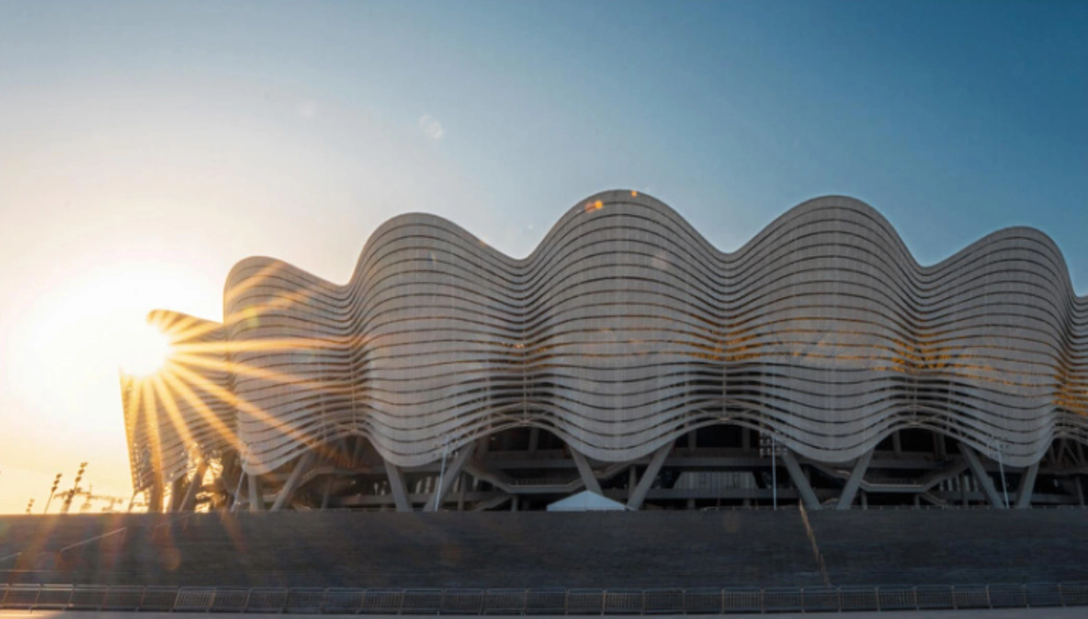 Wave-form metal facade bands and glazed openings on a sports center in Xi'an