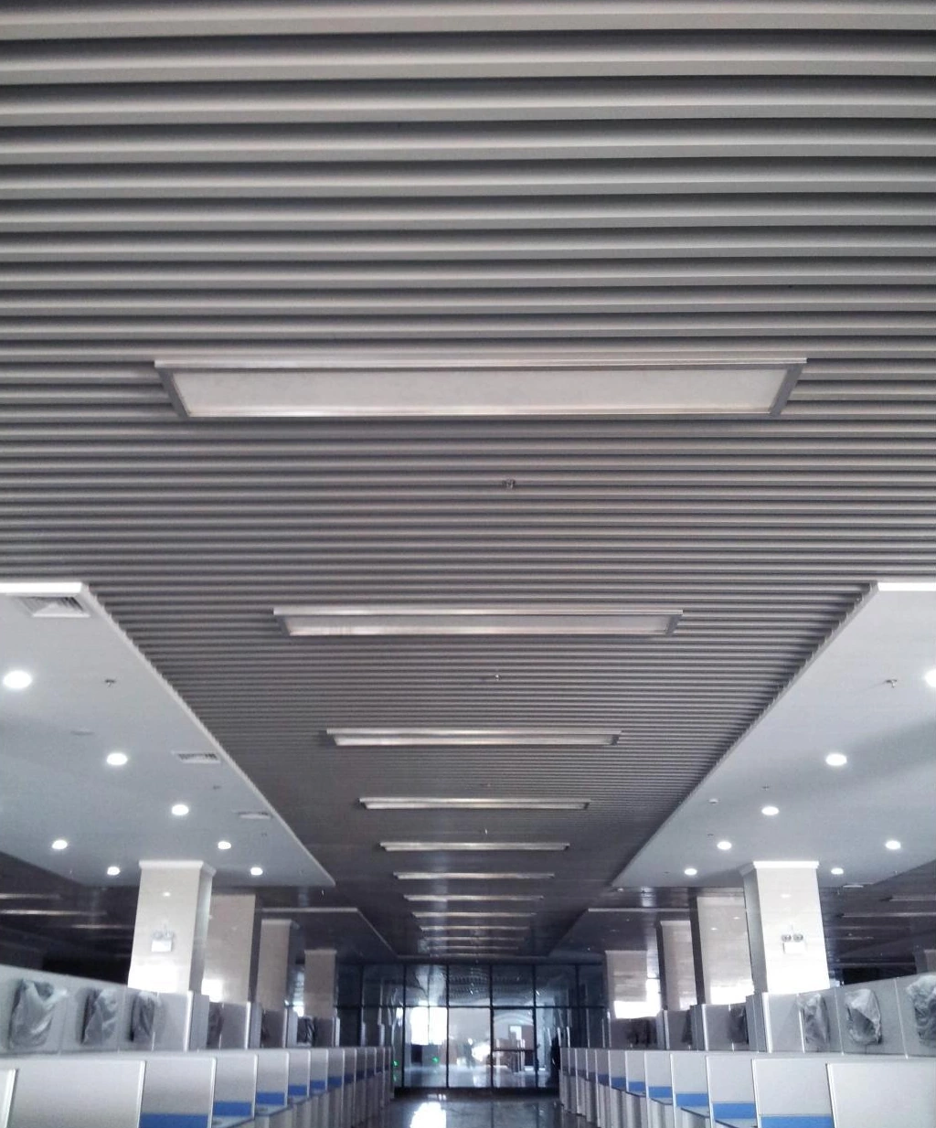 Linear ceiling in a service hall with lighting set into the strip layout