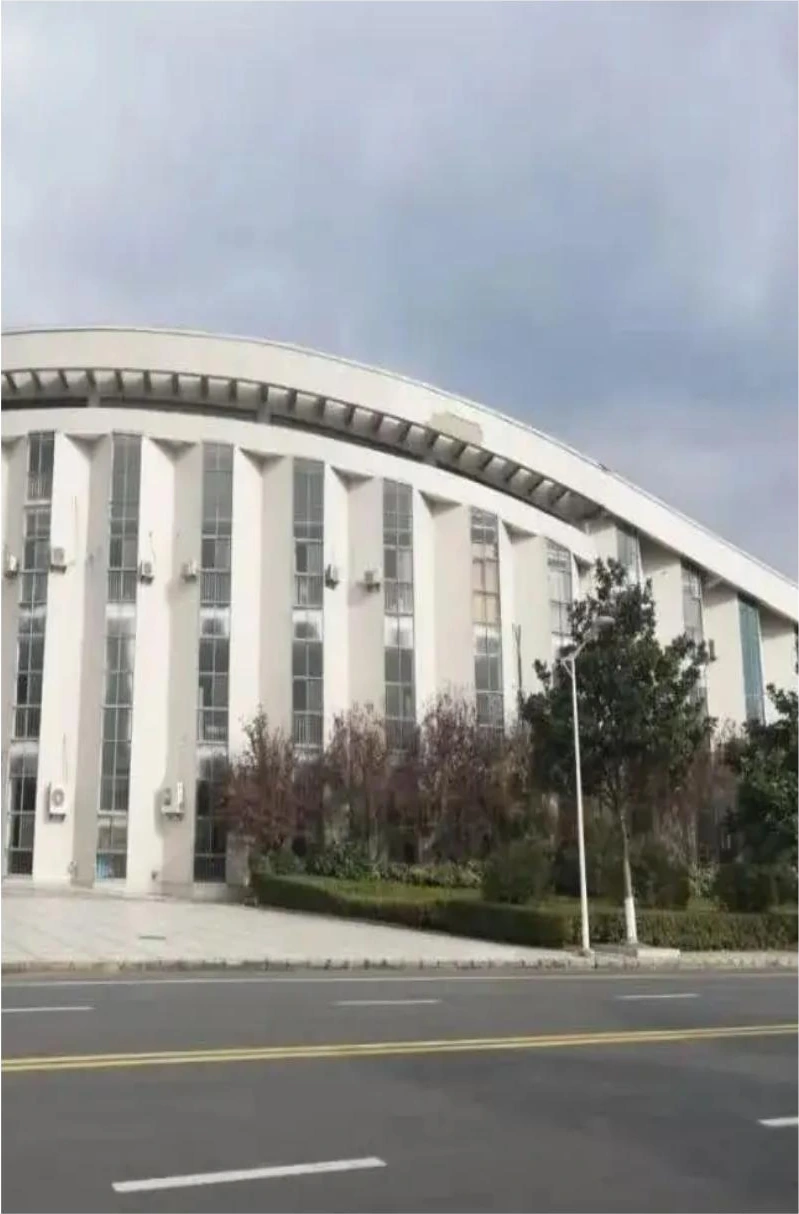 Curved colonnade and pale facade panels on a school building in Yancheng