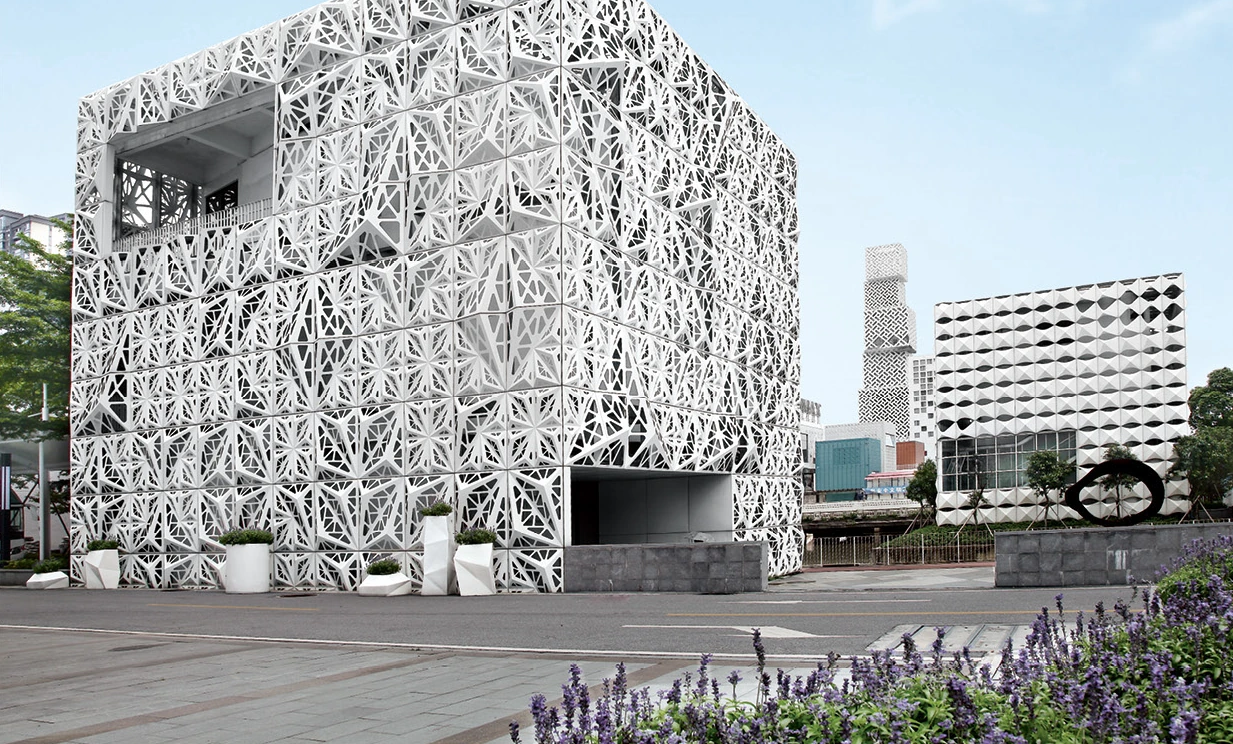 Decorative cut-out aluminum screen wrapping the exterior of a multi-story pavilion