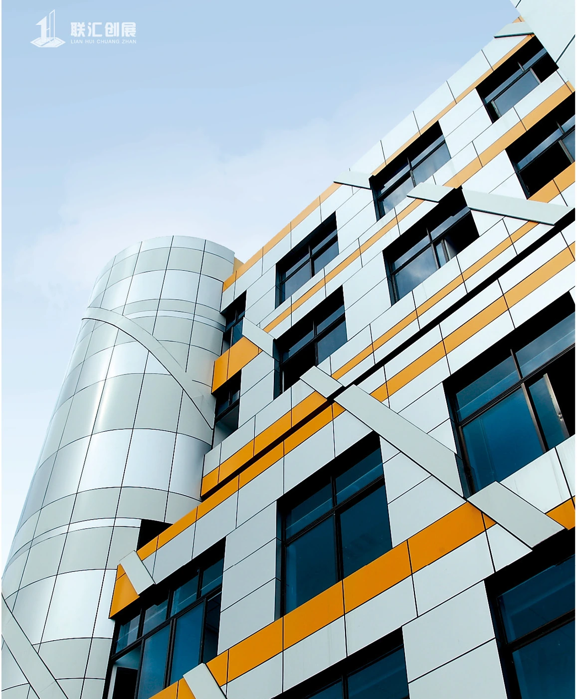 Silver and gold-colored facade panels surrounding office windows on a commercial tower