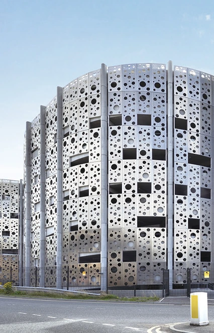 Perforated aluminum facade panels arranged around windows on a cultural building