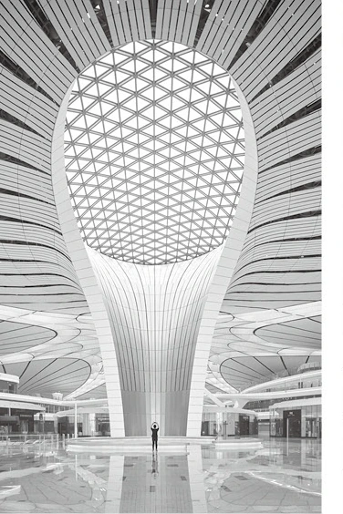 Triangular ceiling grid around a flared column and circular atrium skylight